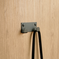 A towel hook in South Africa or a wall hook in South Africa. The wall hook is hanging a black handbag in a luxury design store in South Africa