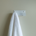 A towel hook in South Africa or a wall hook in South Africa. The wall hook is hanging a white bathrobe