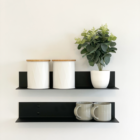 Black steel shelf or black metal wall shelves for the kitchen with mugs and an indoor plant